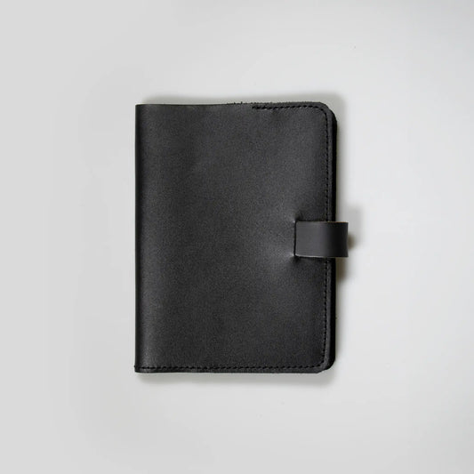 Minimalist black leather notebook showcasing quality New Zealand craftsmanship. Small batch design with tab closure and refined stitching—made to last, perfect men’s gift with vintage appeal.