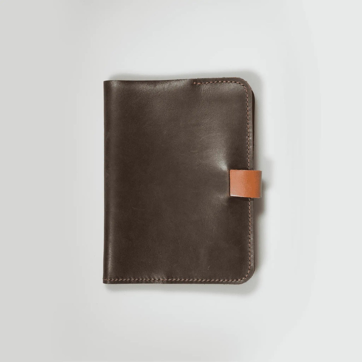 Minimalist A5 brown leather notebook showcasing quality New Zealand craftsmanship. Small batch design with tab closure and refined stitching—made to last, featuring everyday simplicity with vintage workmanship.