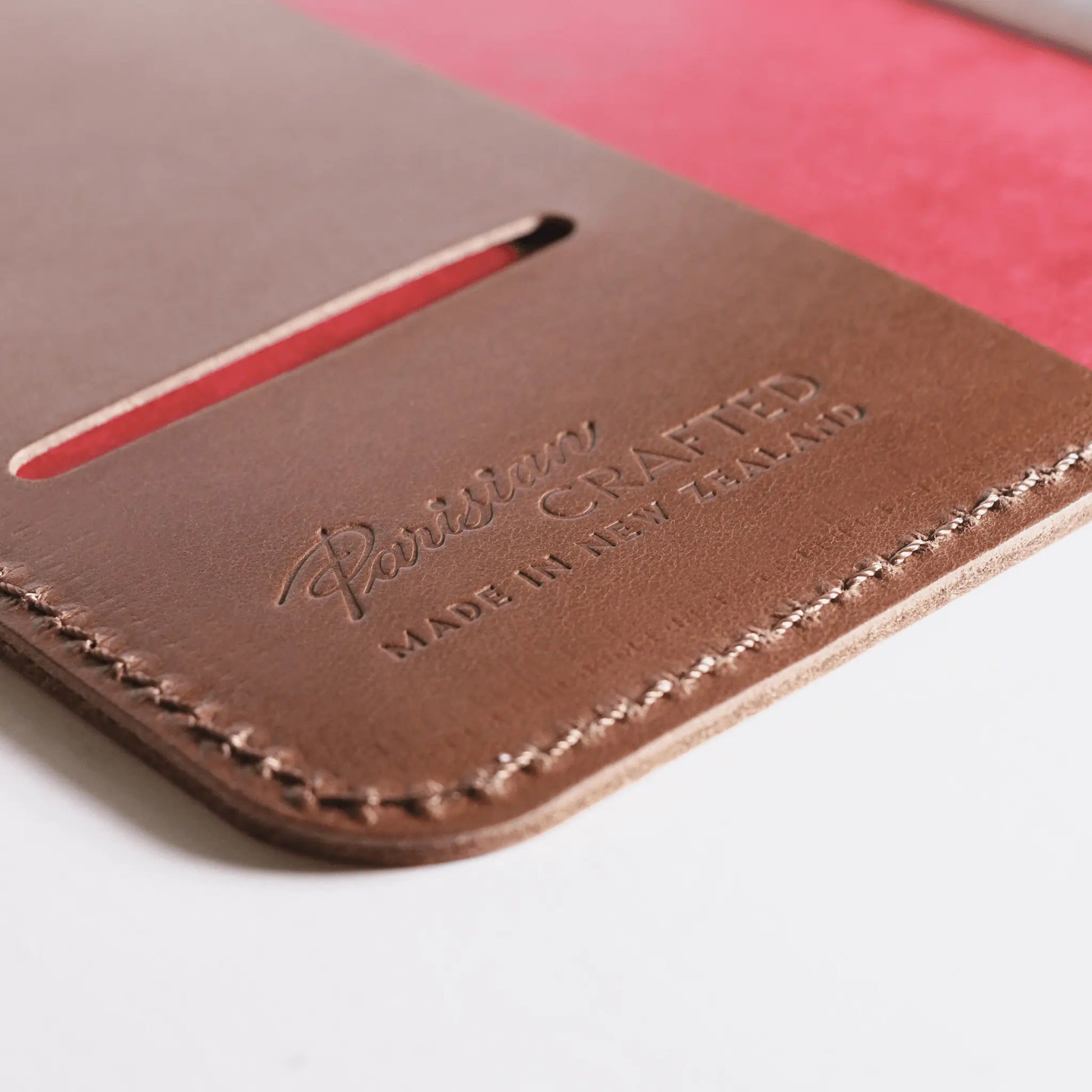 Close-up of the interior of an A5 tan leather notebook, featuring an embossed Parisian Crafted logo and a red interior cover—a genuine leather notebook with timeless style and quality craftsmanship.