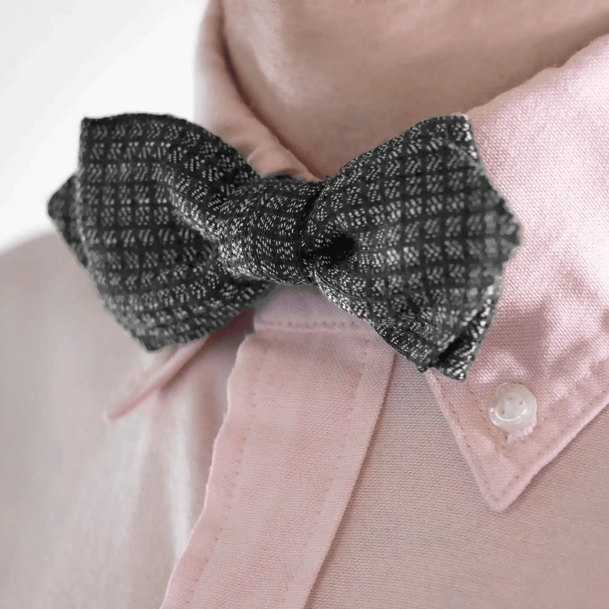 Elegant charcoal bow tie with grey micro square pattern, paired with a contrasting pink men's shirt—designed in New Zealand.