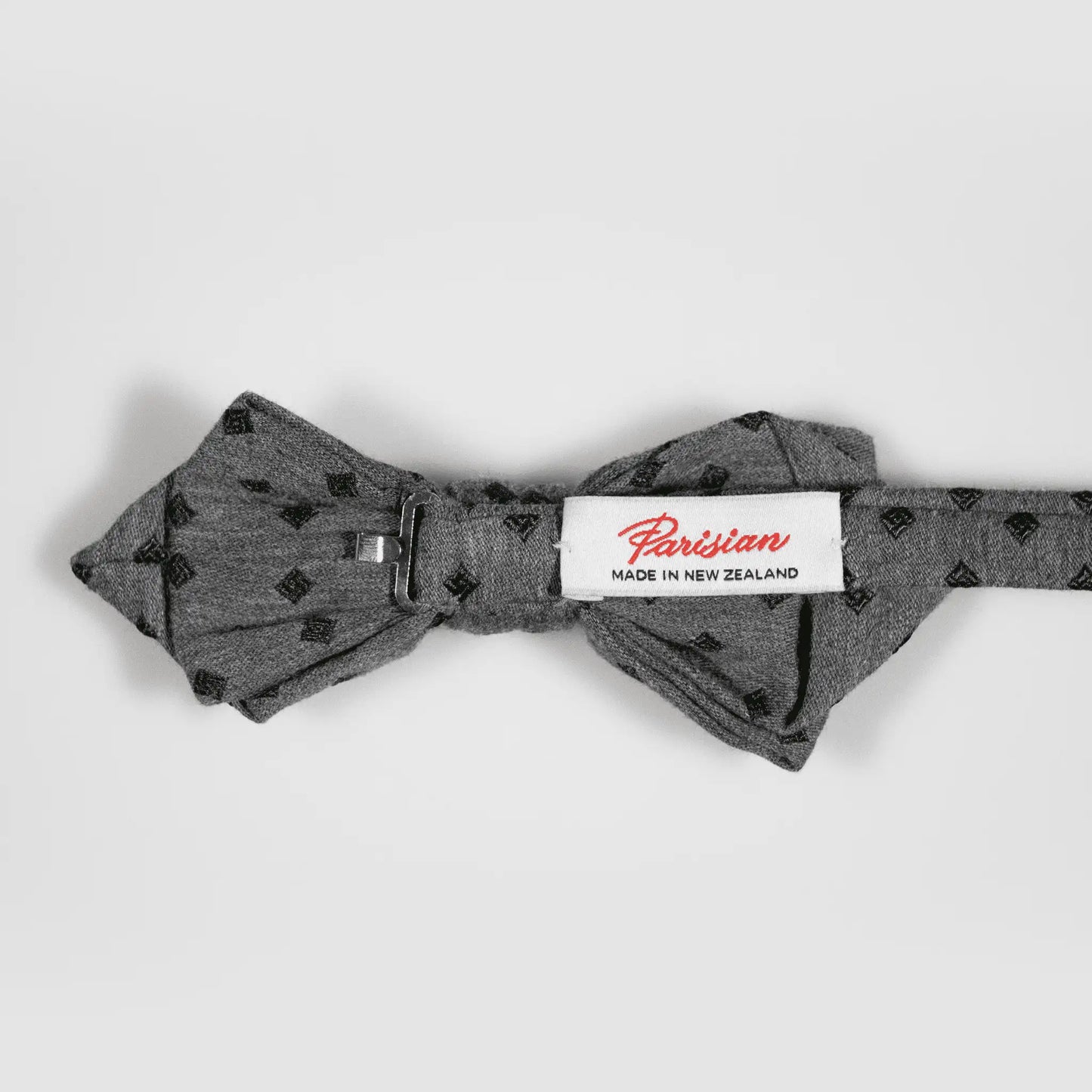 Back of Grey and Olive Diamond Bow Tie showing "Parisian Made in New Zealand" woven label, focusing on quality material and design.