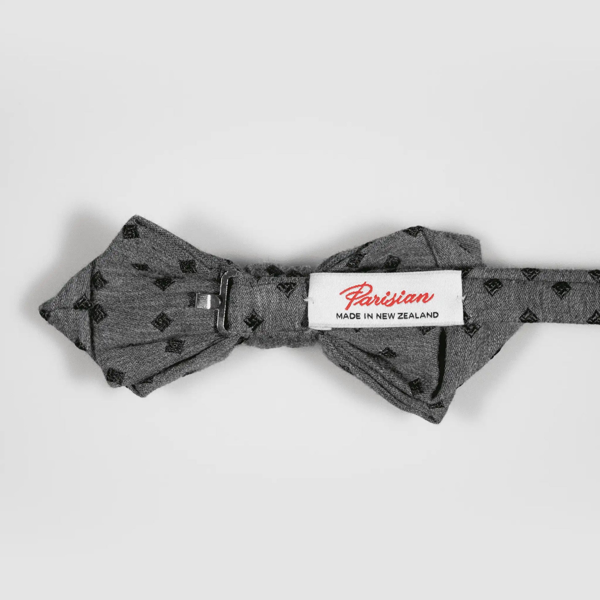 Back of Grey and Olive Diamond Bow Tie showing "Parisian Made in New Zealand" woven label, focusing on quality material and design.
