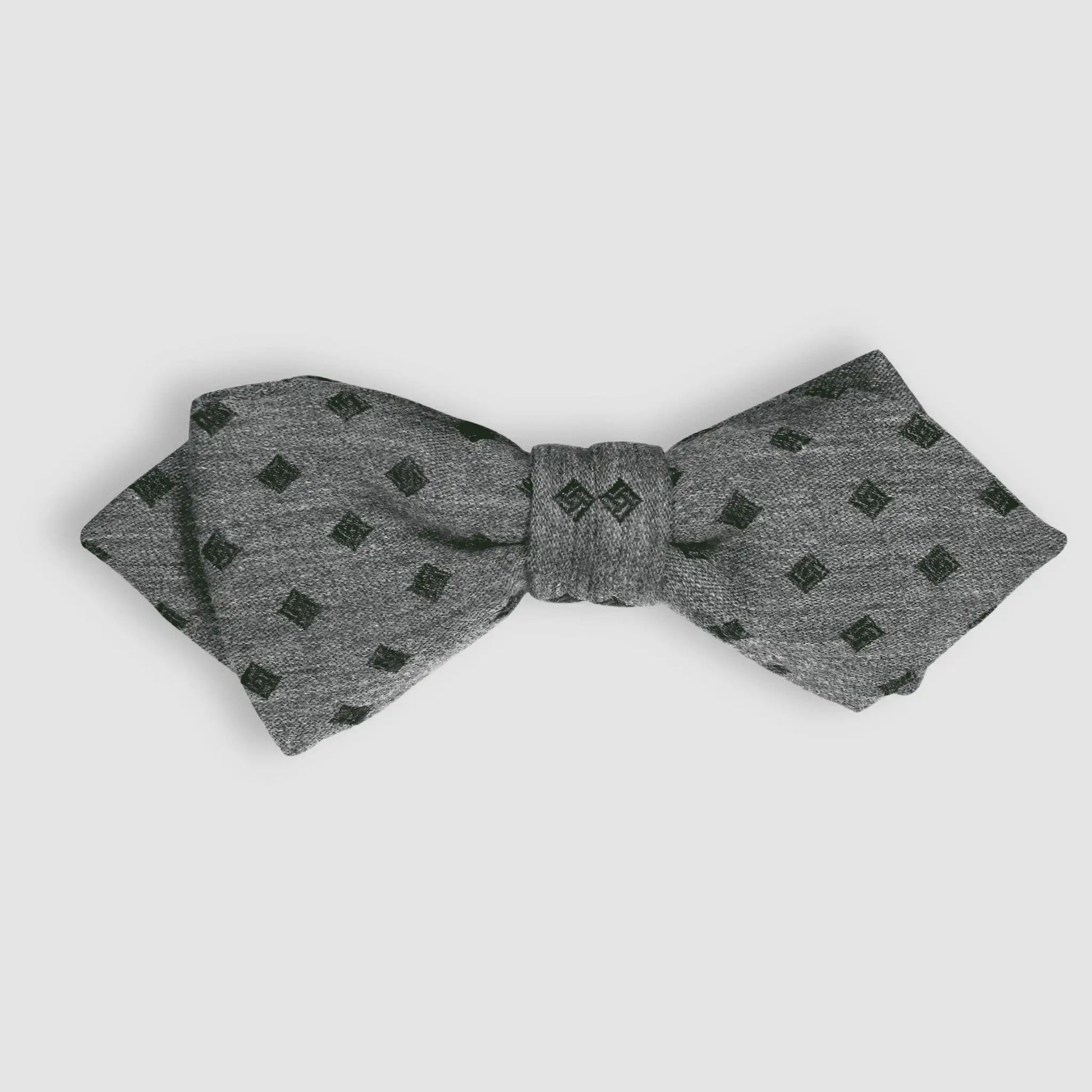 Grey bow tie with olive green diamond pattern, self-tied formal accessory for elegant menswear styling.