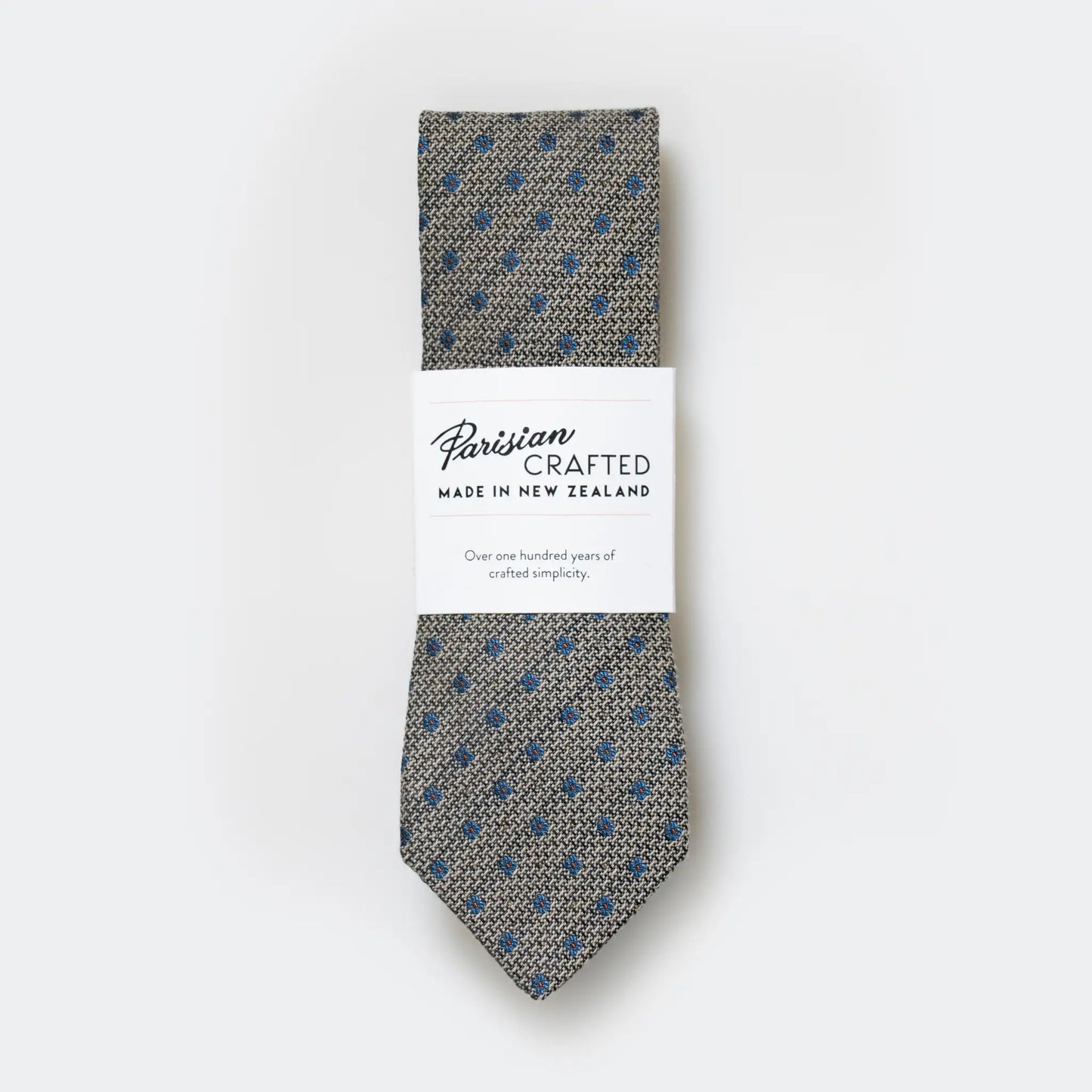 Hessian texture tie with blue flower pattern, folded in Parisian Crafted's white card packaging, showcasing rich texture and simple floral design.