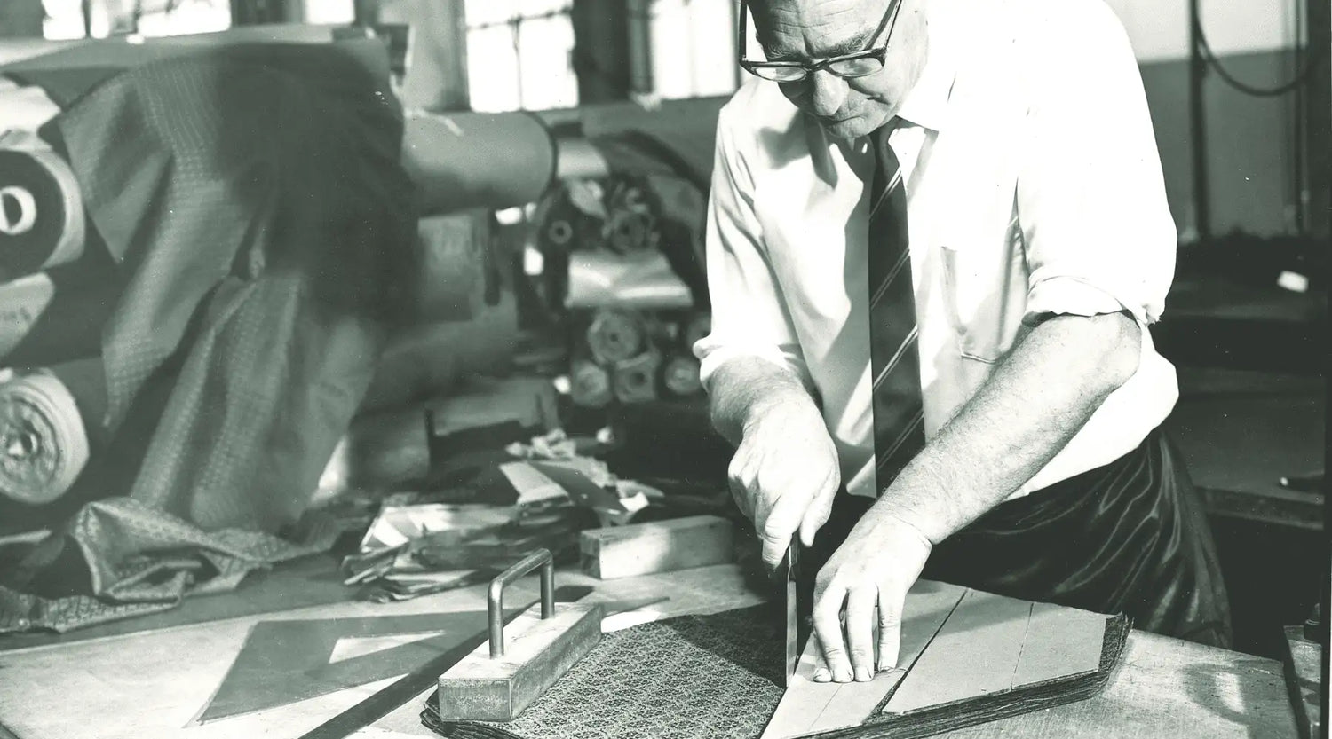Man cutting fabric for a tie in black and white