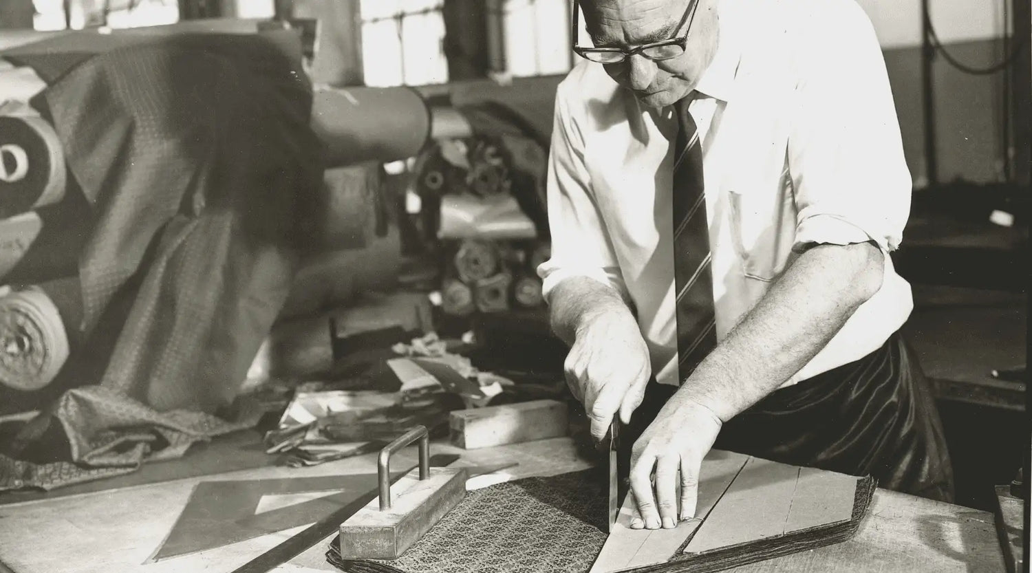 Man cutting fabric for a tie in black and white