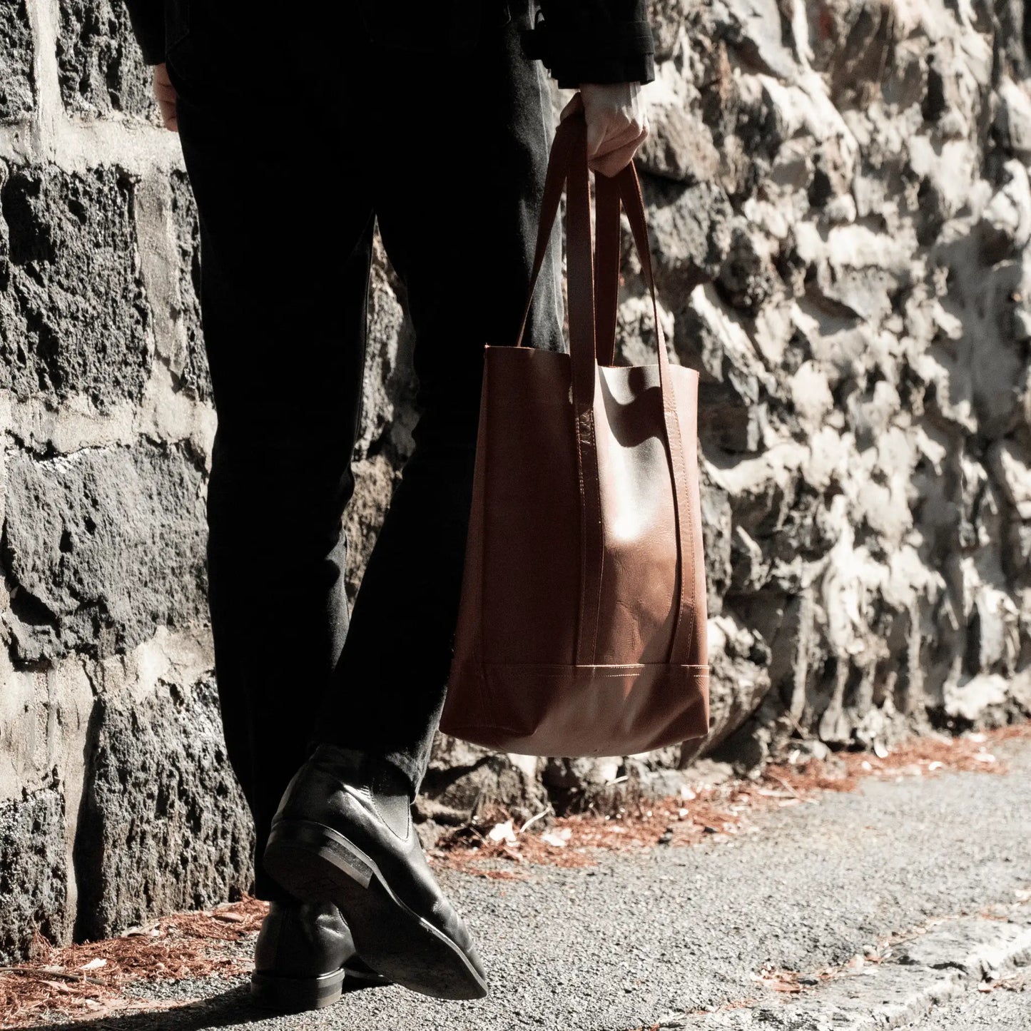 Close-up of man carrying Tan Leather Everyday Tote, highlighting premium craftsmanship and showcasing this timeless New Zealand accessory.