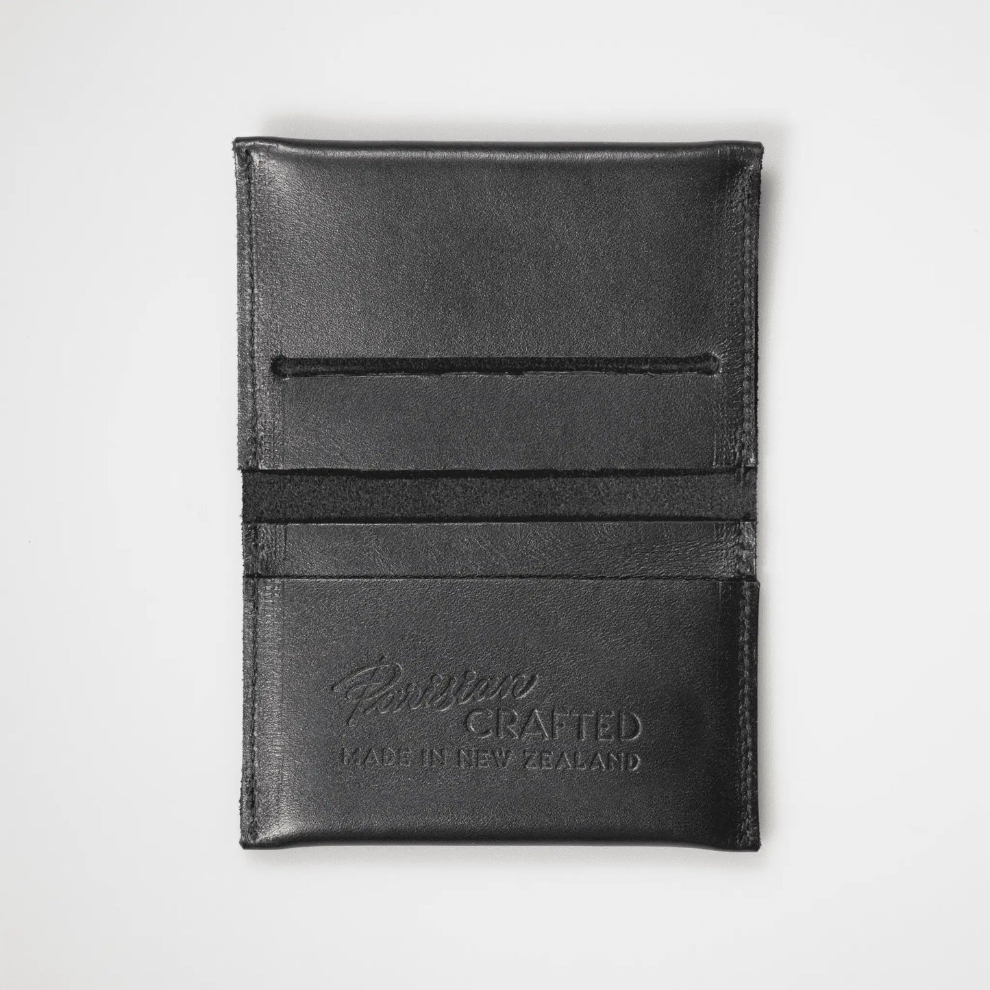 Black Leather Card Wallet opened to showcase "Parisian Crafted Made in New Zealand" embossing. Expertly crafted New Zealand men's accessory with functional design and fine grain leather texture.