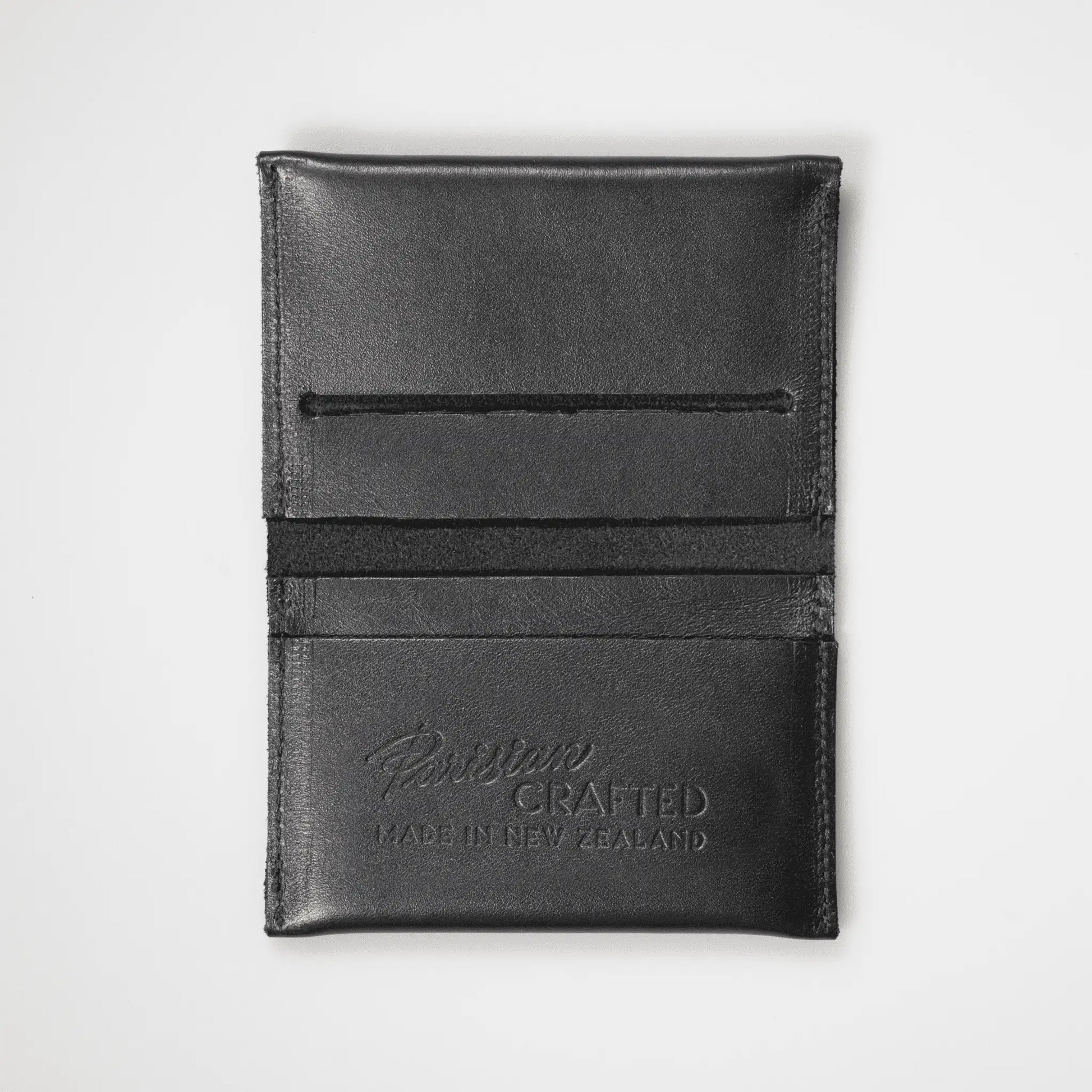 Black Leather Card Wallet opened to showcase "Parisian Crafted Made in New Zealand" embossing. Expertly crafted New Zealand men's accessory with functional design and fine grain leather texture.