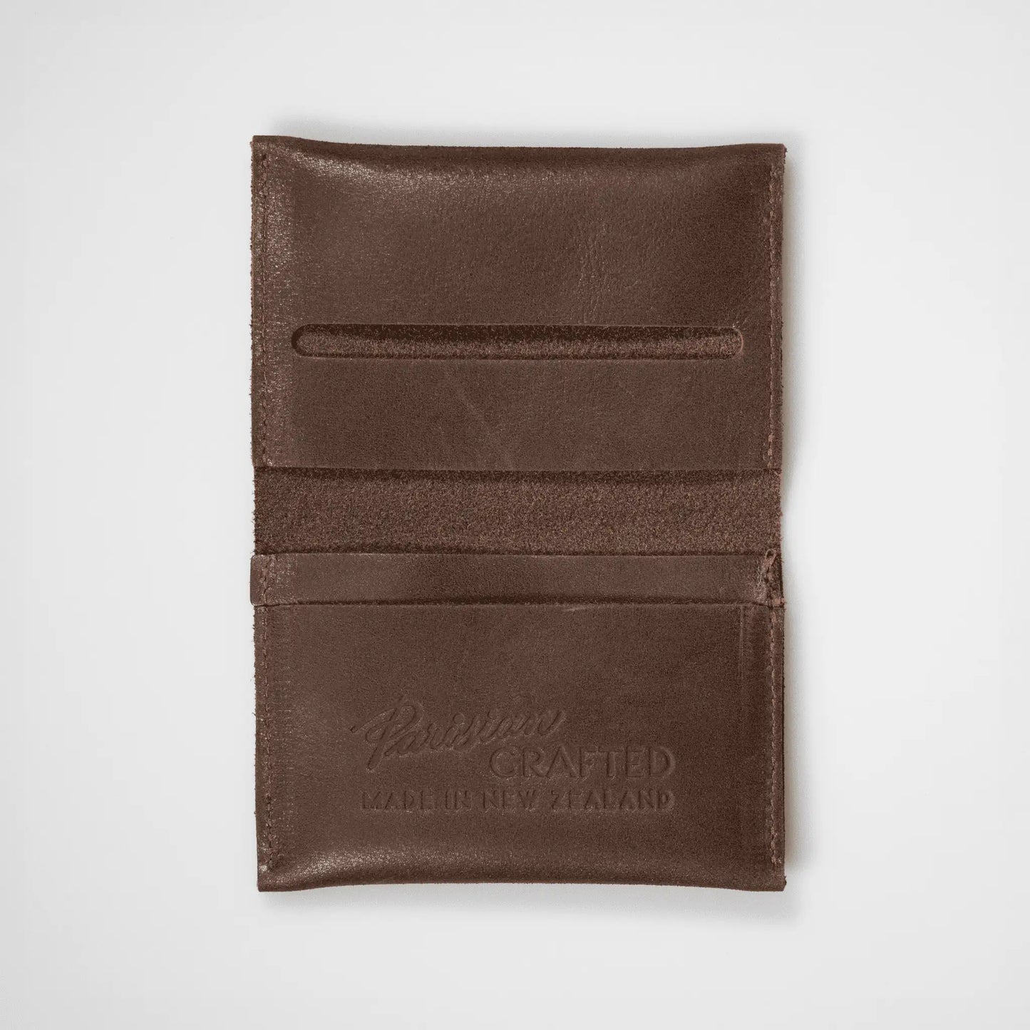 Brown leather folded card wallet open on a white background, showcasing its functional design and quality craftsmanship.