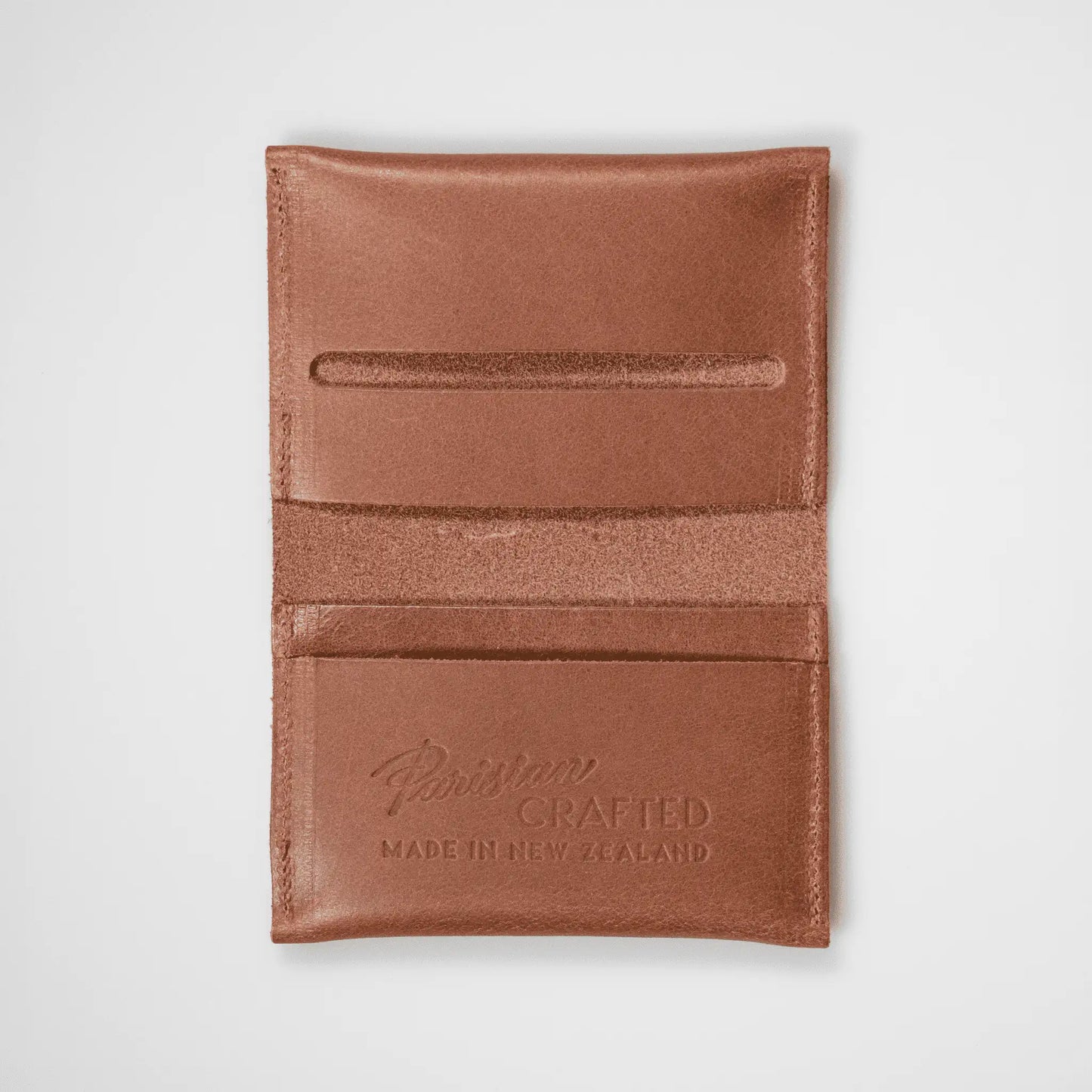 Tan leather folded card wallet open on a white background, highlighting quality craftsmanship and functional design.
