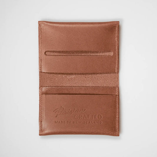 Tan leather folded card wallet open on a white background, highlighting quality craftsmanship and functional design.