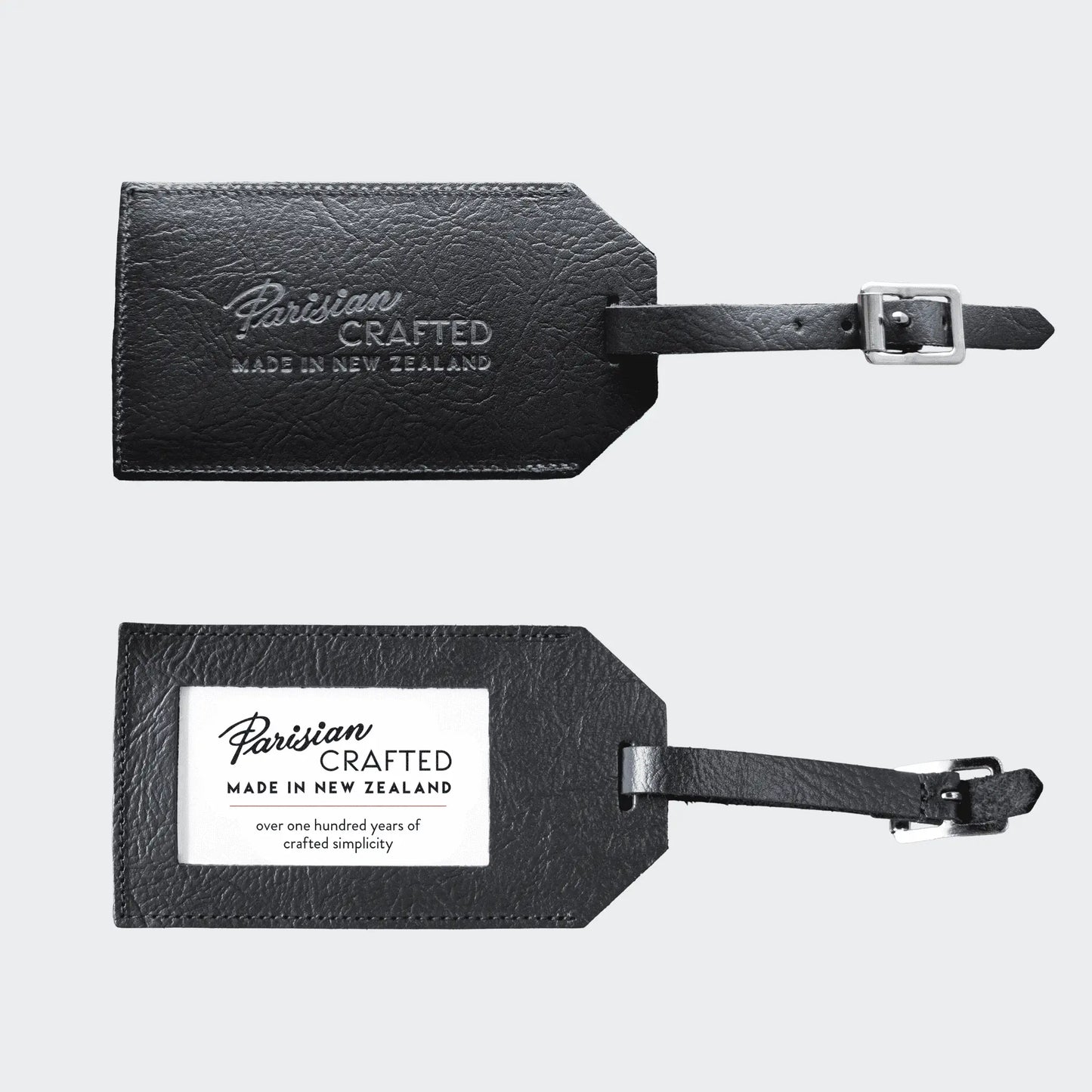 Front and back of black leather luggage tag with 'Parisian Crafted' branding on a light gray background.