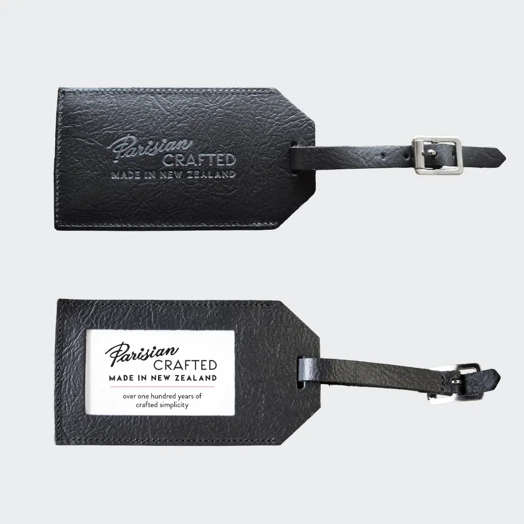 Front and back of black leather luggage tag with 'Parisian Crafted' branding on a light gray background.