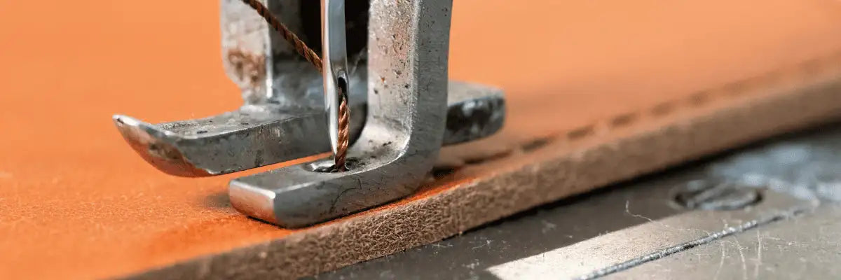 Close-up of a machine stitching a leather notebook