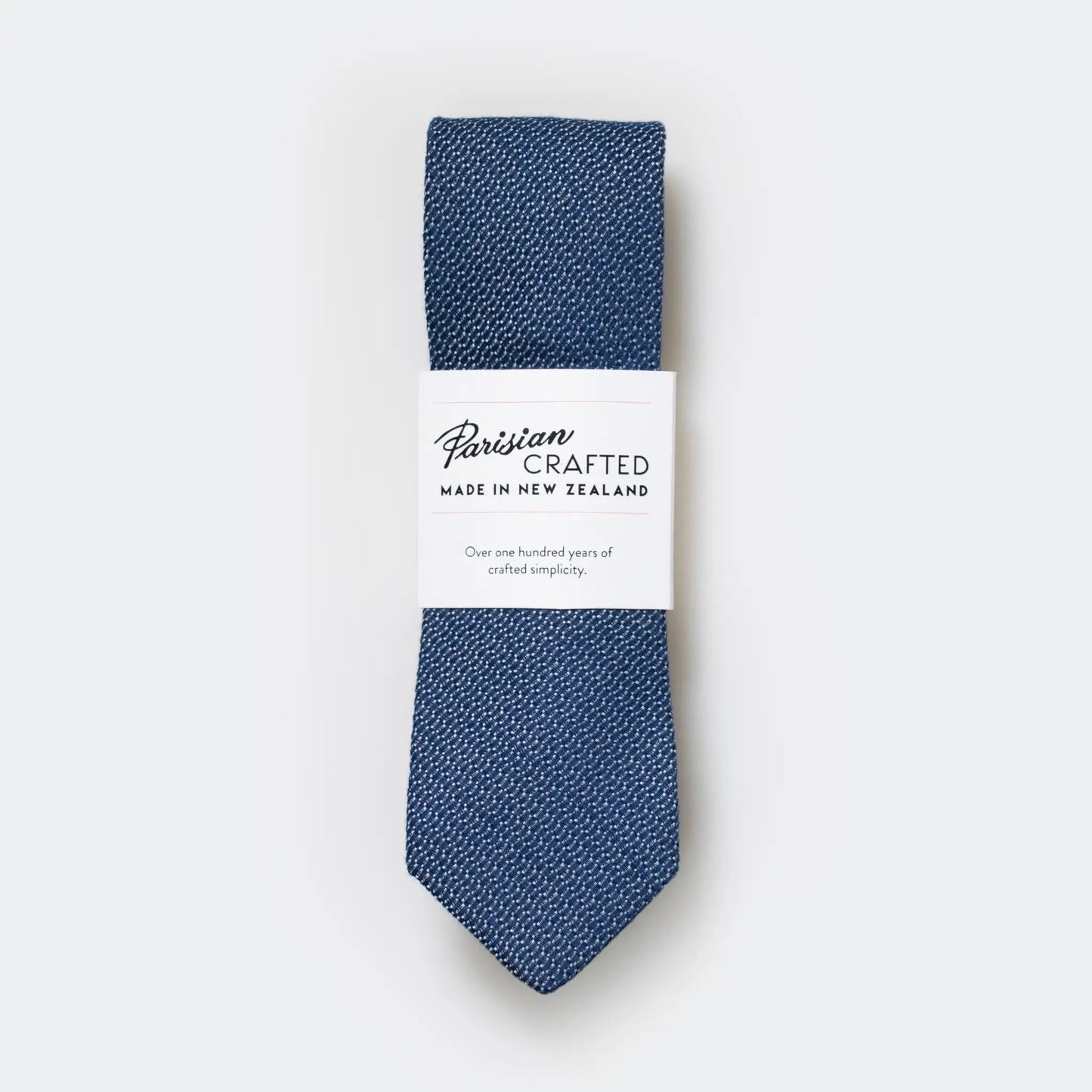 Mid Blue and White Jacquard Tie in Parisian Crafted's white card packaging, folded neatly, showcasing detailed woven texture.