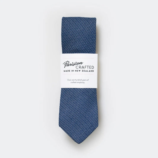 Mid Blue and White Jacquard Tie in Parisian Crafted's white card packaging, folded neatly, showcasing detailed woven texture.