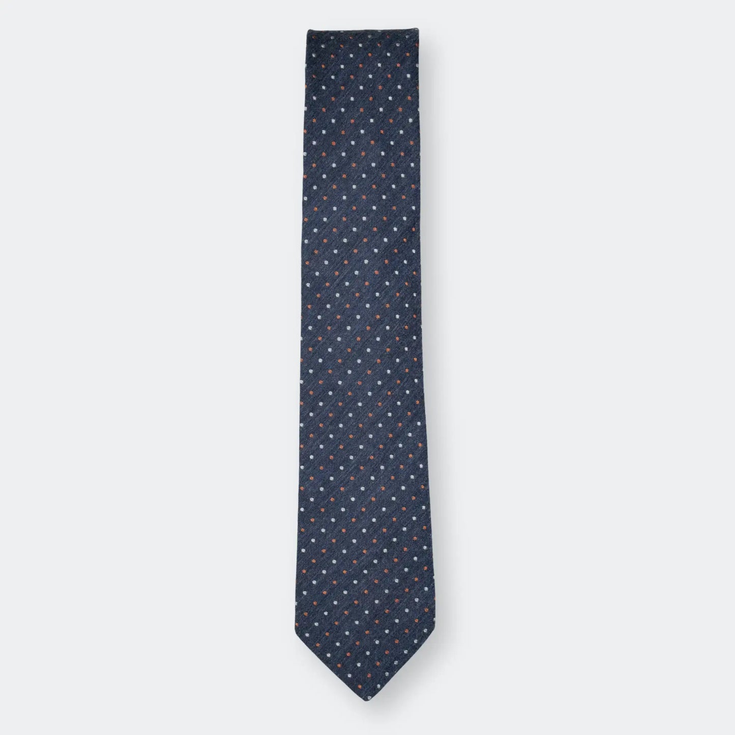 Parisian Crafted's cotton-blend tie in denim blue with a white and rust pin-dot design, folded neatly and displayed on a white background.
