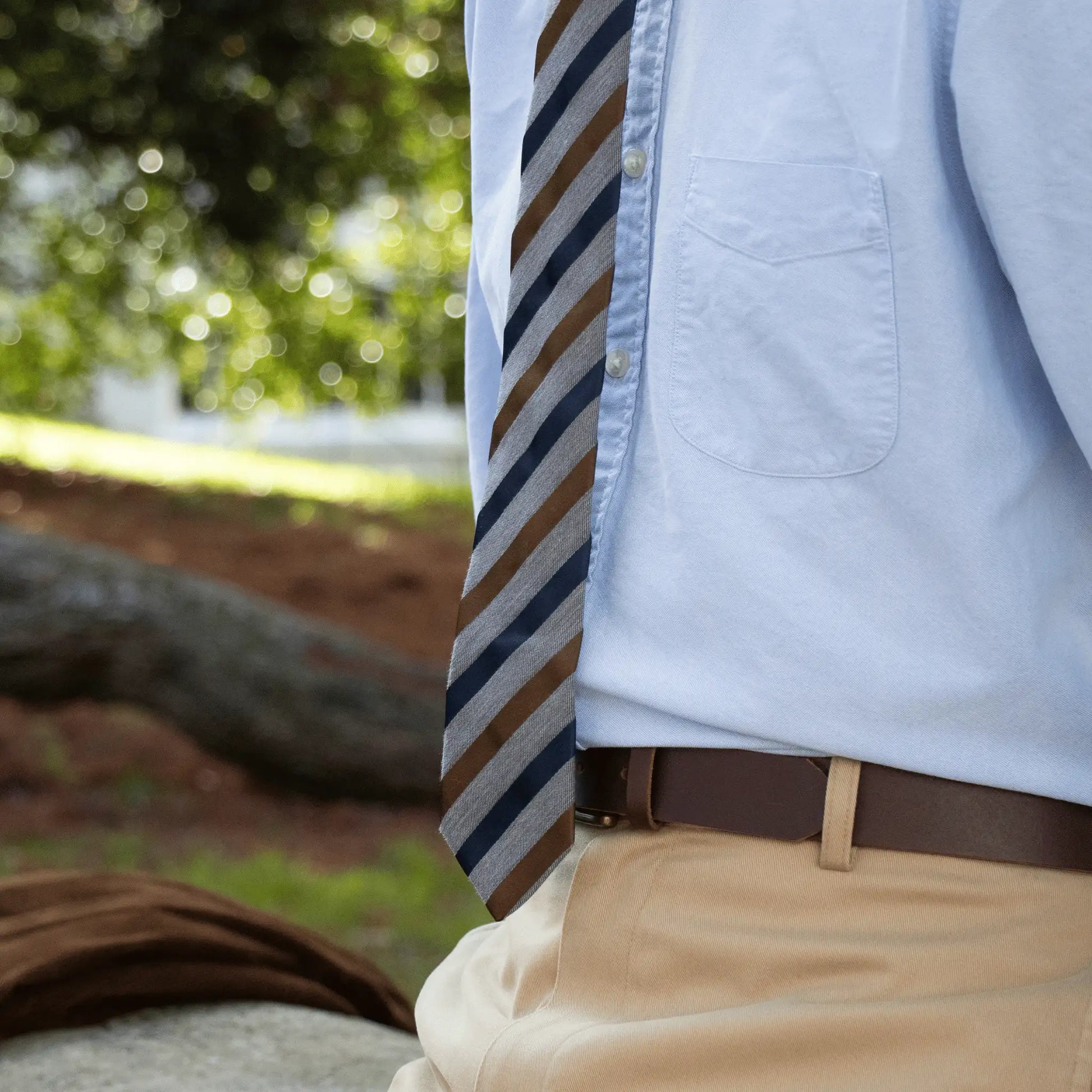 Close-up of a man wearing the grey, navy and tobacco striped tie from Parisian Crafted - New Zealand made cotton ties for work.
