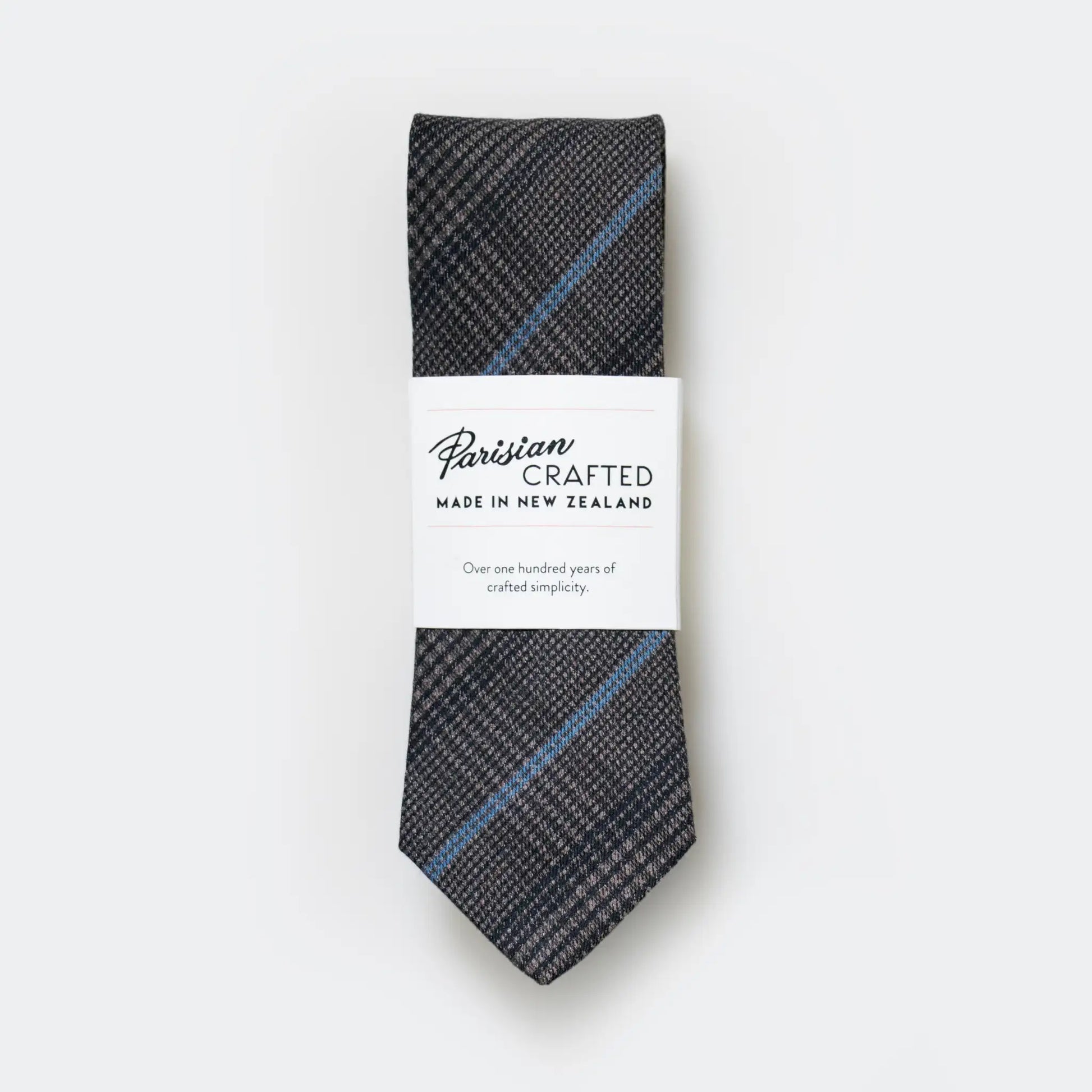 Slate and blue check tie made from a cotton-blend by Parisian Crafted, folded neatly into a sleek white packaging sleeve.