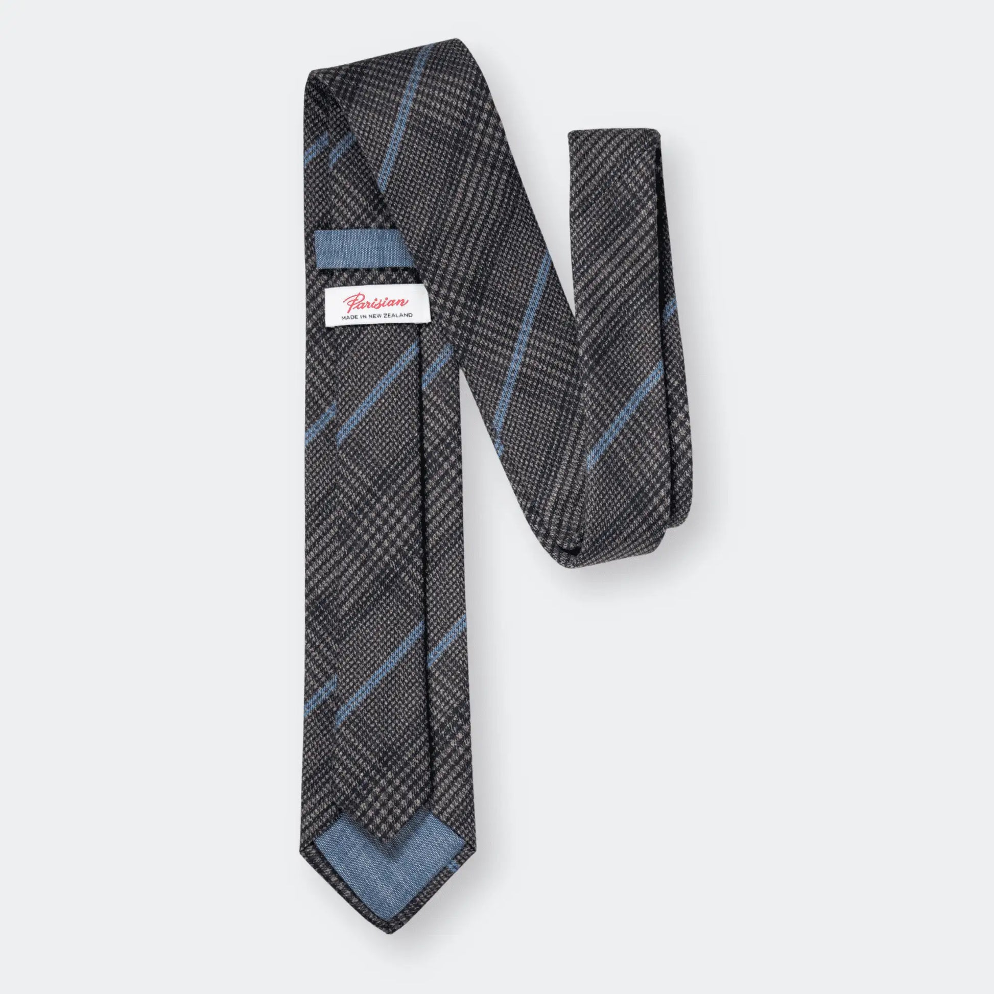 Back of the slate blue check tie, showcasing 'Parisian Made in New Zealand' woven label emphasising quality materials and craftsmanship.