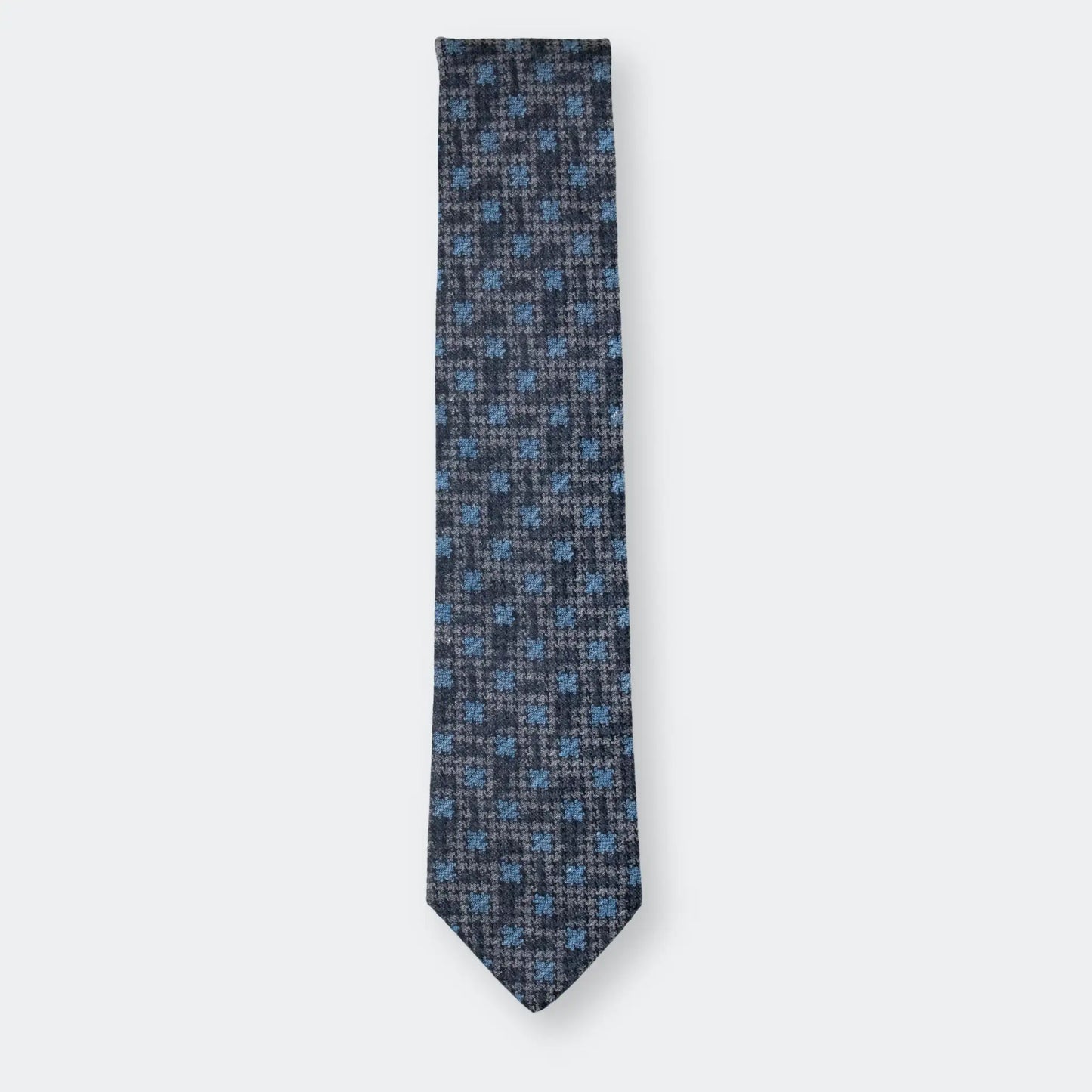 Abstract houndstooth design tie in slate blue, folded in half on a white background - handmade in New Zealand.