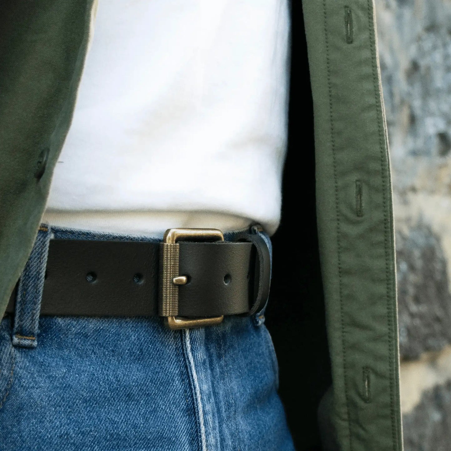 Close-up of wide black leather belt styled with white T-shirt and green button-down—premium New Zealand men’s accessory.