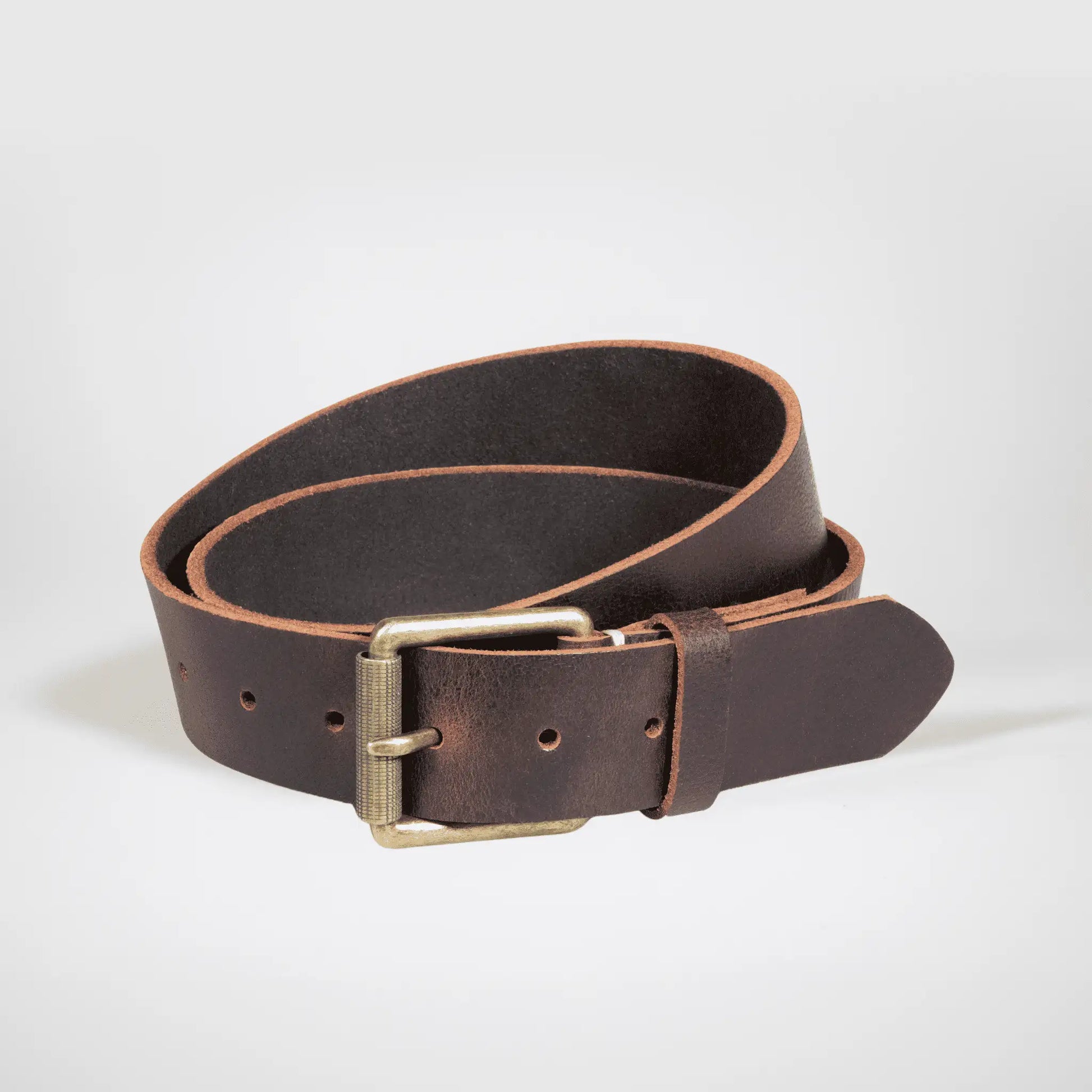Brown Leather work belt rolled up on white surface, highlighting premium craftsmanship and minimalist design—quality NZ accessory.