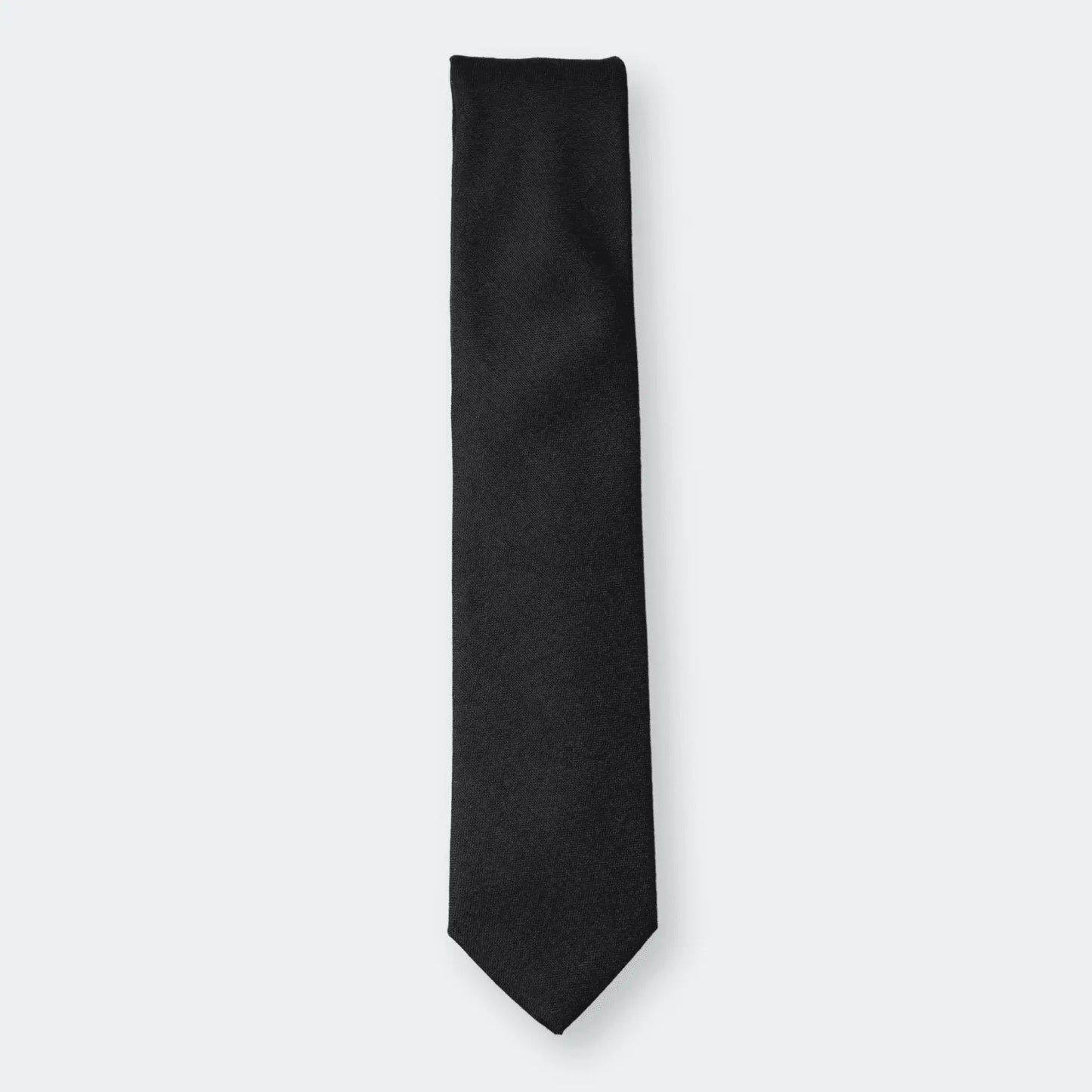 The pure black worsted wool tie folded on a white background - showcasing refined design and premium craftsmanship.