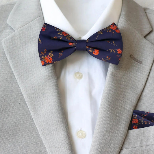 Navy and red floral bow tie from Liberty London worn with a gray suit and white shirt.