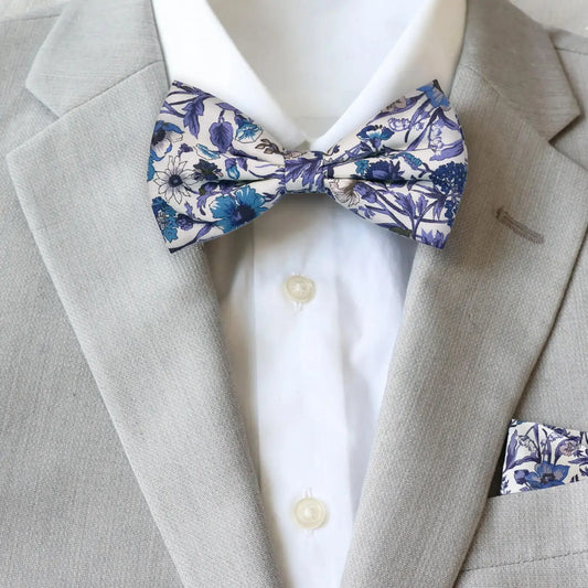 Gray suit with a white shirt and blue and purple Liberty London floral bow tie