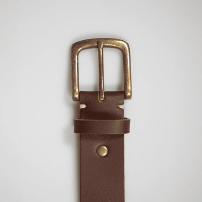 Close-up of simple brass buckle on a rustic brown genuine leather men's belt. Crafted in New Zealand and perfect for gifting.