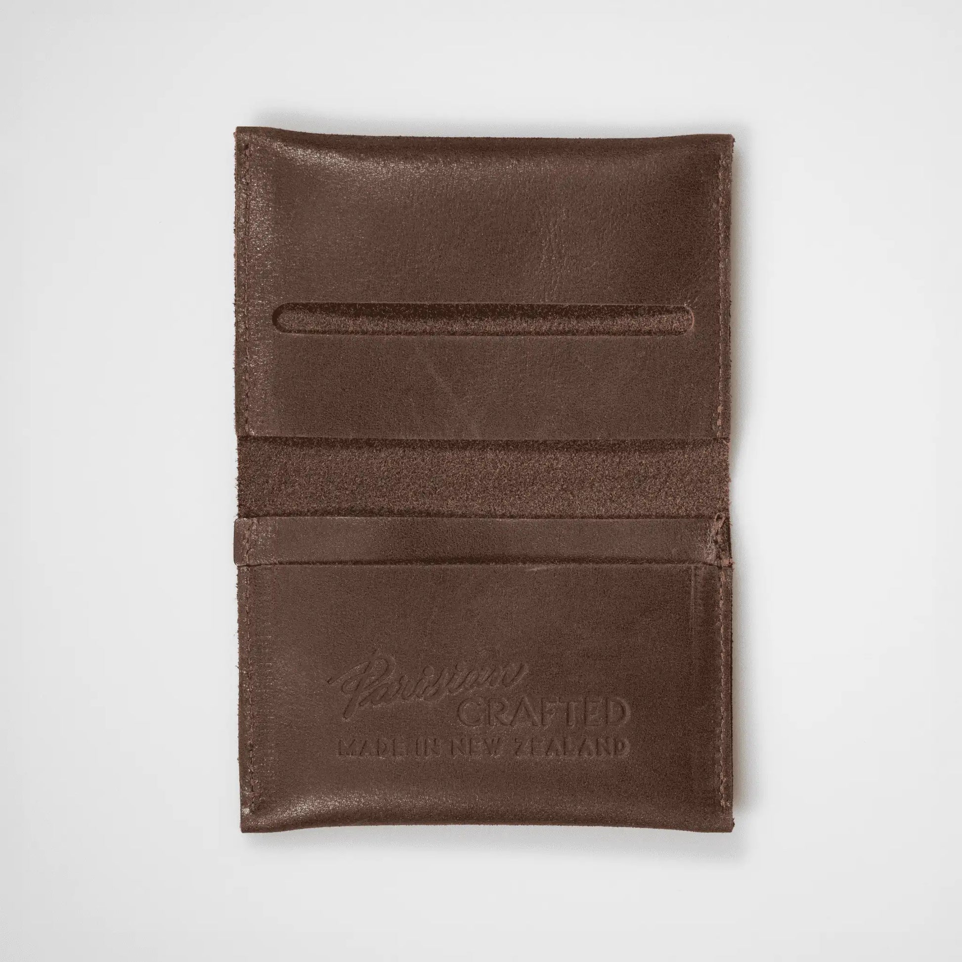 Brown leather folded card wallet open on a white background, showcasing its functional design and quality craftsmanship.