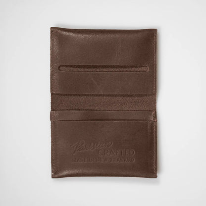 Brown leather folded card wallet open on a white background, showcasing its functional design and quality craftsmanship.