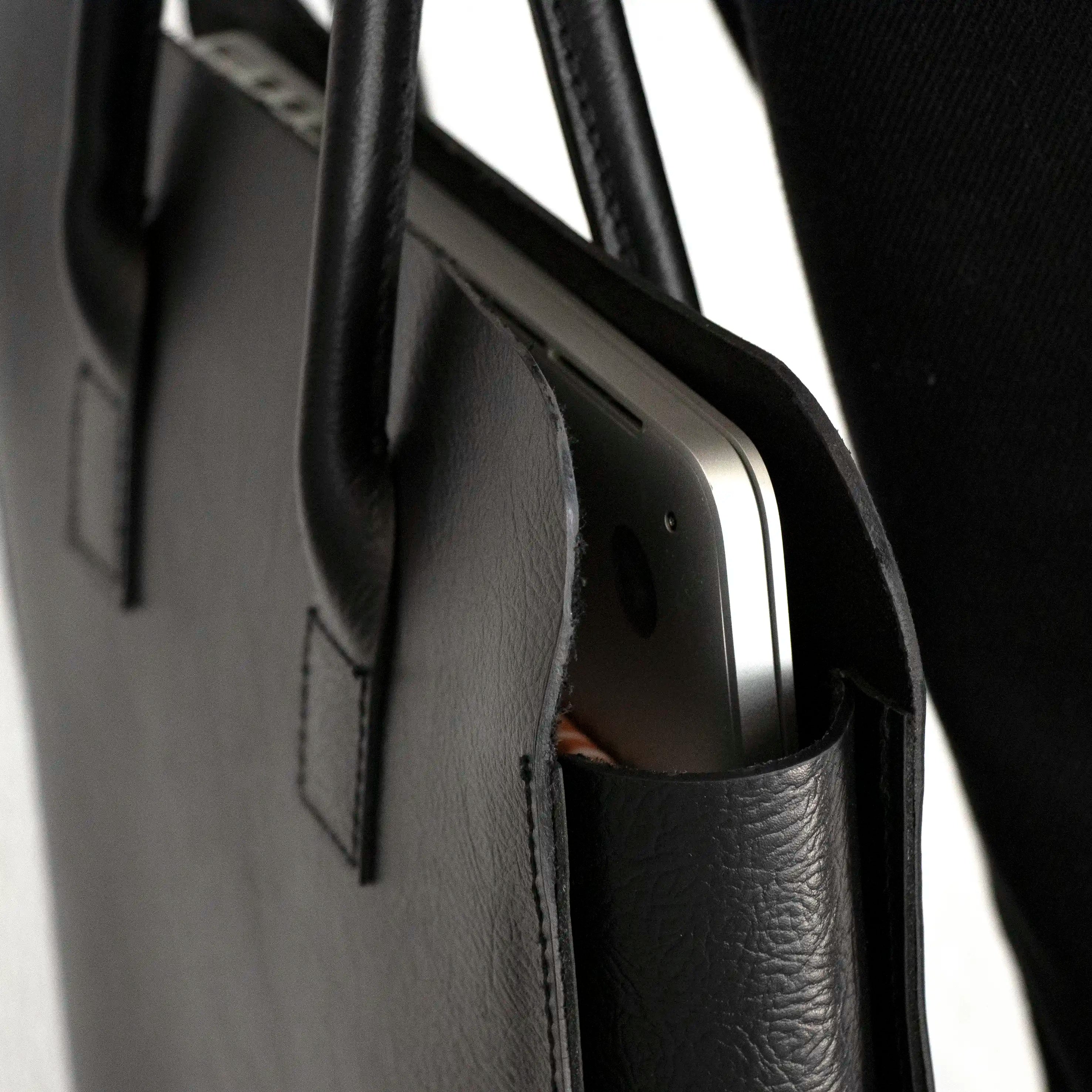 A close up of a laptop in the Black Leather Business Tote.