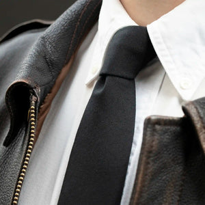 The Pure Black Worsted Wool Tie worn with a Leather jacket and a White Button Down Shirt.