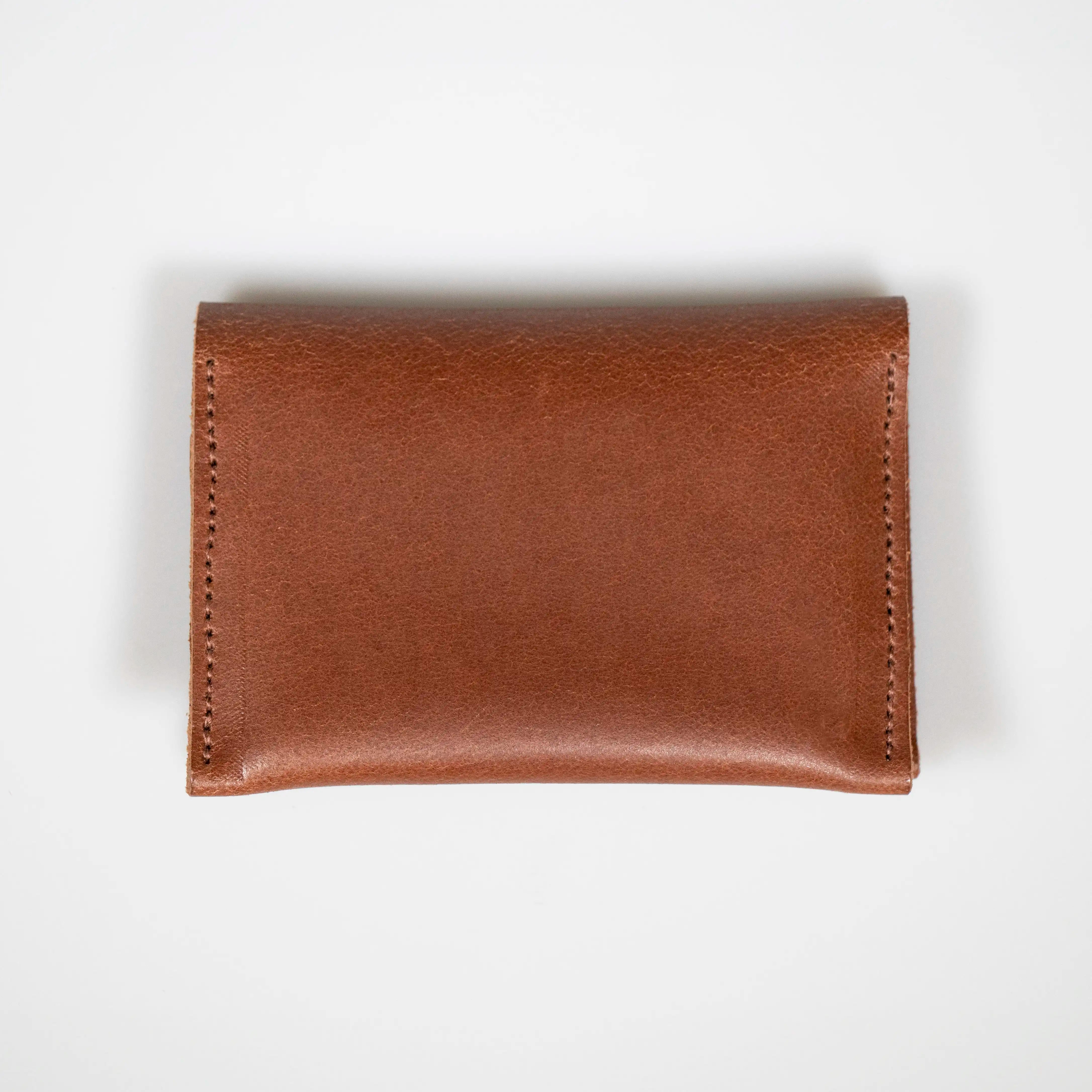 A closed Tan Leather Folded Card Wallet sitting on a white background